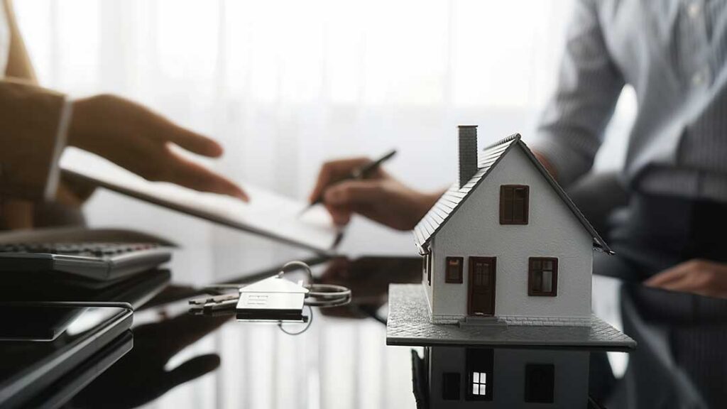 Homeowner reviews insurance documents beside household photos, receipts, and a calculator at a kitchen table